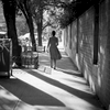 A woman walks west on 4th street on a hot summer day. 