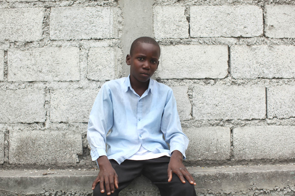 Croix Des Bouquets, Haiti - Orphans of the January 12th earthquake are gathered in a field next to Lycee Jacques, a primary school. They are under the care of FRADES, a grass organization which is providing foster care. Portrait of orphan Jerry Bernard, 12.  - Ozier Muhammad/The New York Times