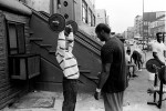 May, 1994 - A man lifts weights and gets a shout of encouragement at 125th street and 5th avenue.