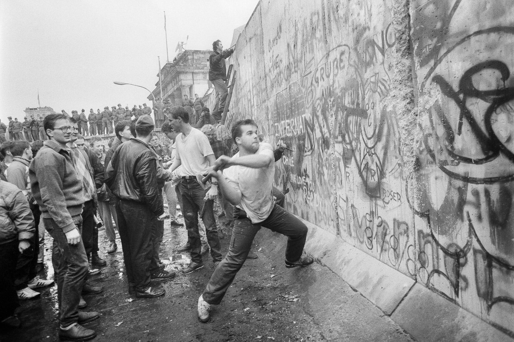 A West Berliner hitting the wall next to the Brandenburg Gate on November 10, 1989