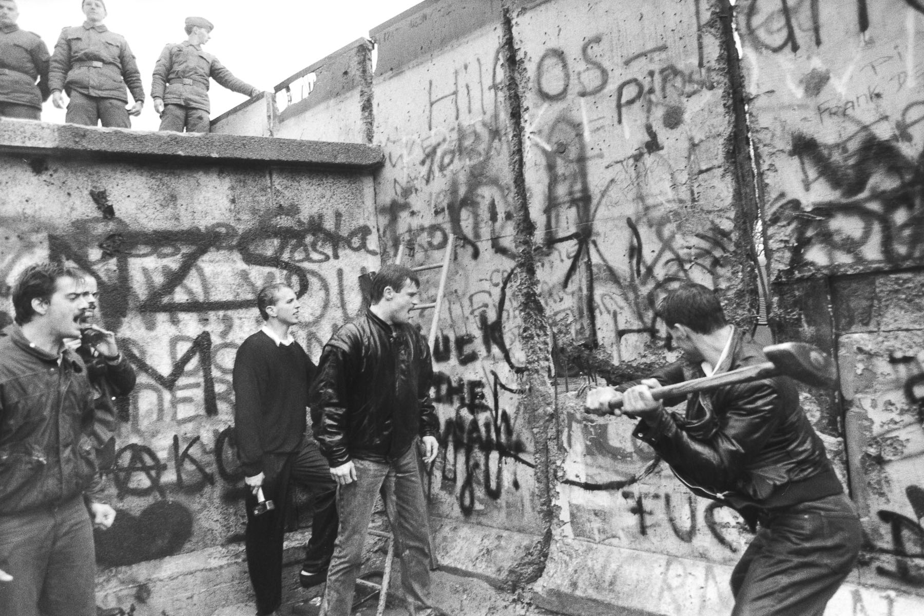 A West Berliner hitting the wall next to the Brandenburg Gate on November 10, 1989