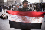 An anti-government demonstrator shows a bloody Egyptian flag during a clash with President Mubarak's supporters on Tahrir Square on Wednesday February 2 2011
