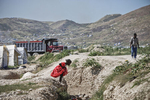 A girl trying to cross a ditch in Corail Camp, a camp for homeless, the victims of the January 12, 2010 earthquake on Thursday, November 25, 2010
