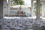 Children playing among the ballot papers scattered after the polling station has been wrecked on Monday, November 29, 2010