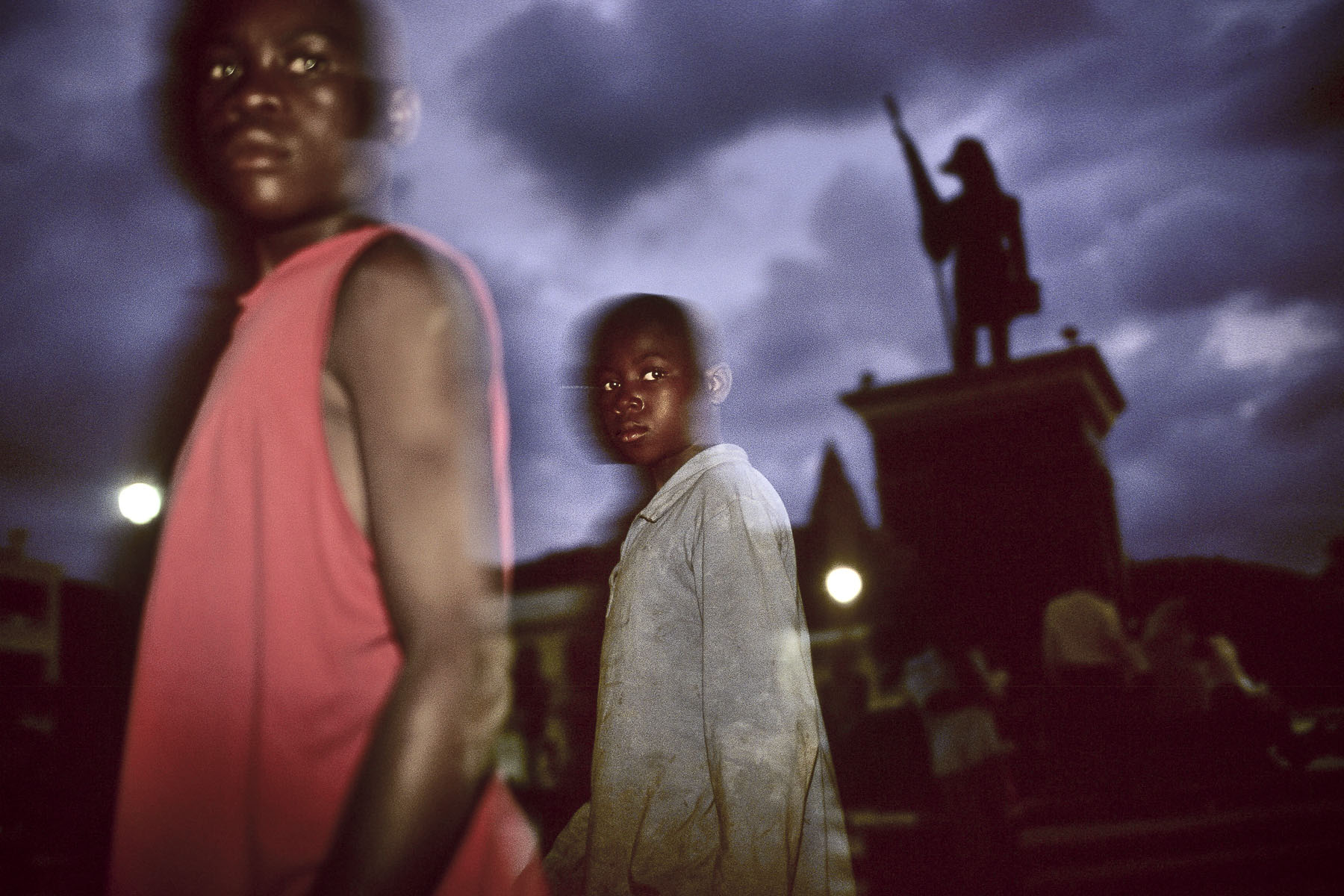 Two children on Cathedral Place beneath the statue of Jean-Jacques Dessalines, the 1st emperor of Haiti in October 2003