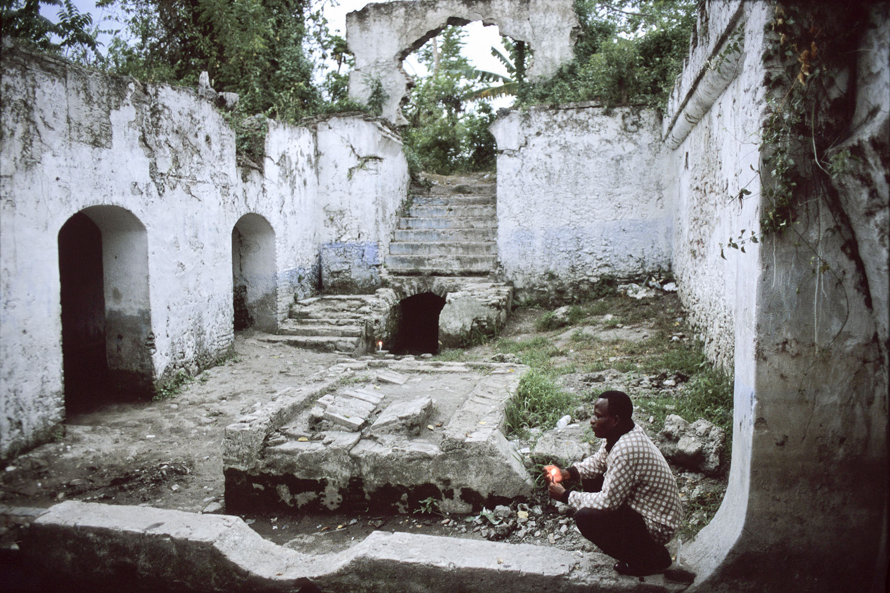 In the ruins of the Duplaa estate, a former plantation, a voodoo adept prays to  Lovana, a voodoo spirit and the new mistress of the house in October 2003