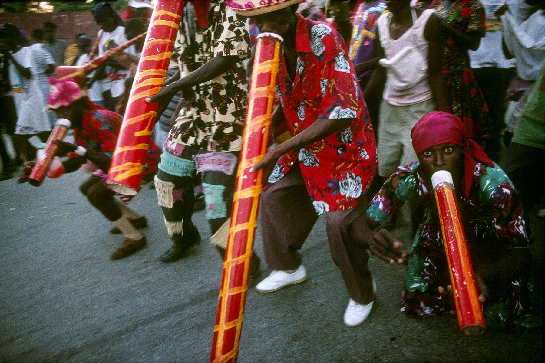 The musicians of a Rara band walking on a road at the entry to the city of Gonaïves on Easter day in April 1994