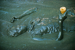 A mambo praying in the mud basin in the center of the village, during the annual pilgrimage dedicated to the loa (spirit) Ogou Feray in July 1994