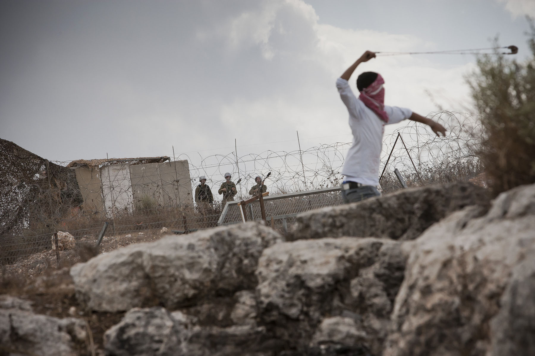 Palestinian young people demonstrates face of the Israeli separation barrier in October 2010
