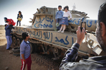 Libyan families by a destroyed tank near the town of Benghazi in April 2011