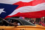 A man waved a Puerto Rican flag along the parade route during the annual Puerto Rican People's Parade on West Division Street in Chicago.