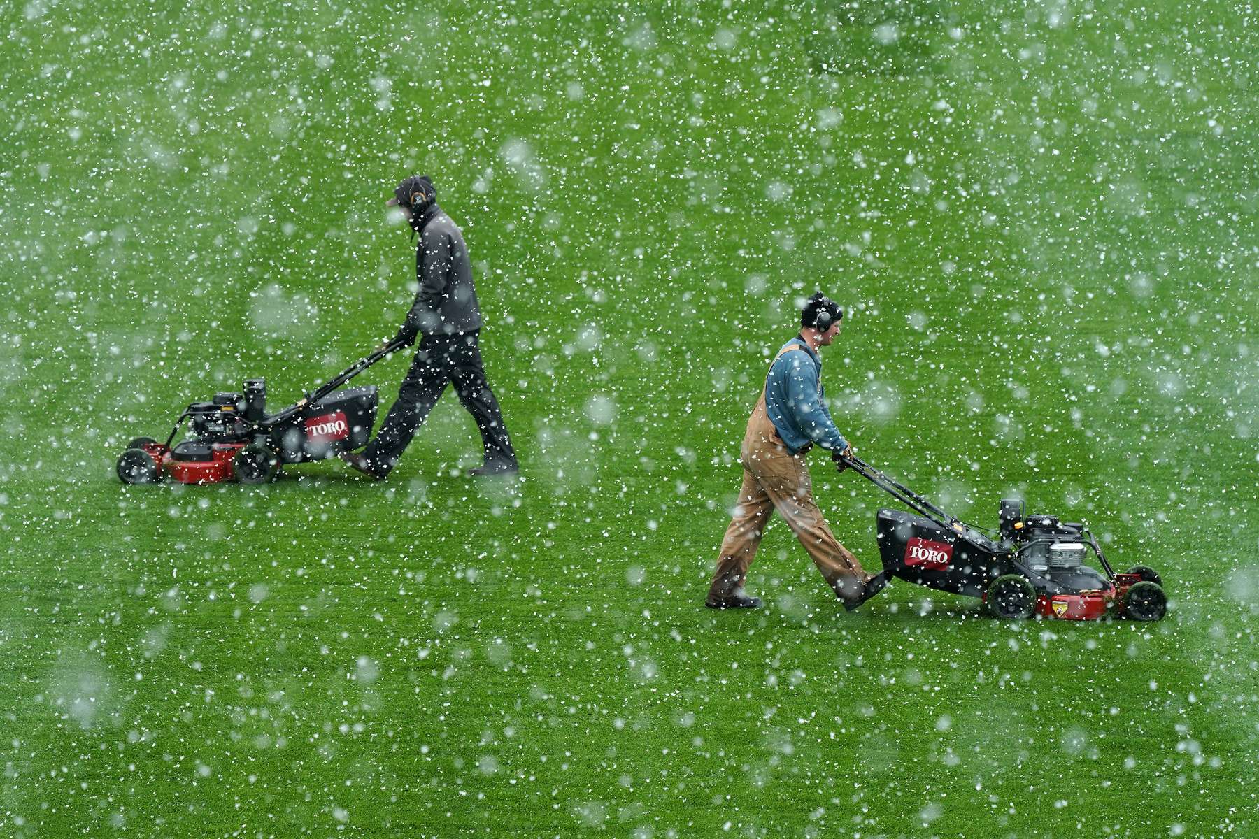 Members of the grounds crew cut the grass at Allianz Field amid heavy snow flurries ahead of their season home opener in St. Paul, Minn.