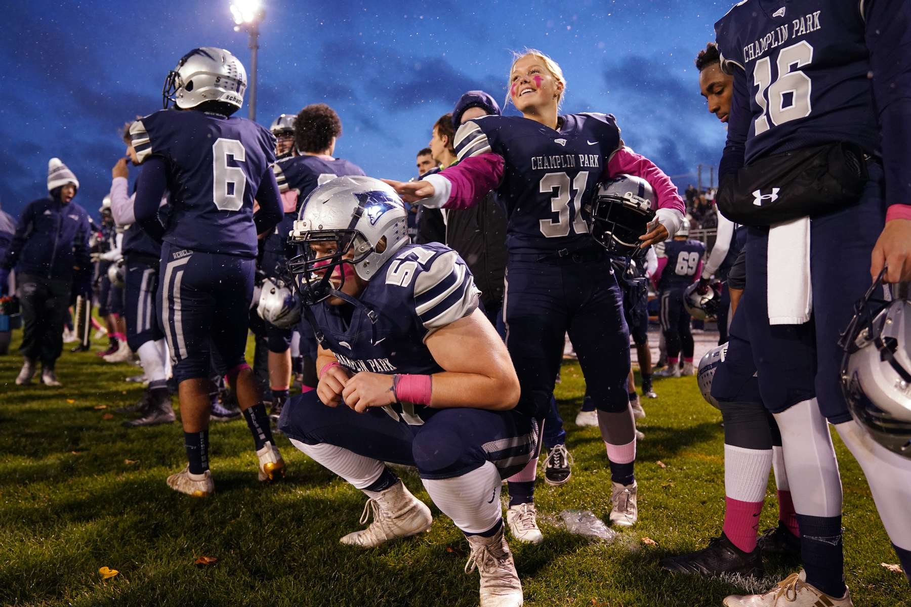 Champlin Park defensive back Holly Johnson gave her teammate defensive lineman Gavin Rosstedt a pat on the helmet as he waited on the sidelines ahead of a game against Totino-Grace in Champlin, Minn. 