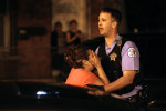 Police officer Russell Pitzer held back a mother as she was overcome with emotion upon arriving at the scene where three people were shot, including her son who was killed, in the 2500 block of South Ridgeway Avenue in Chicago. 