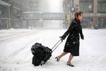 Delta Airlines flight attendant Victoria Flees trudged through the snow with her bags in downtown Minneapolis on the way back home from the light rail station after her flight to Paris was grounded along with all other planes at MSP because of a severe April snowstorm.