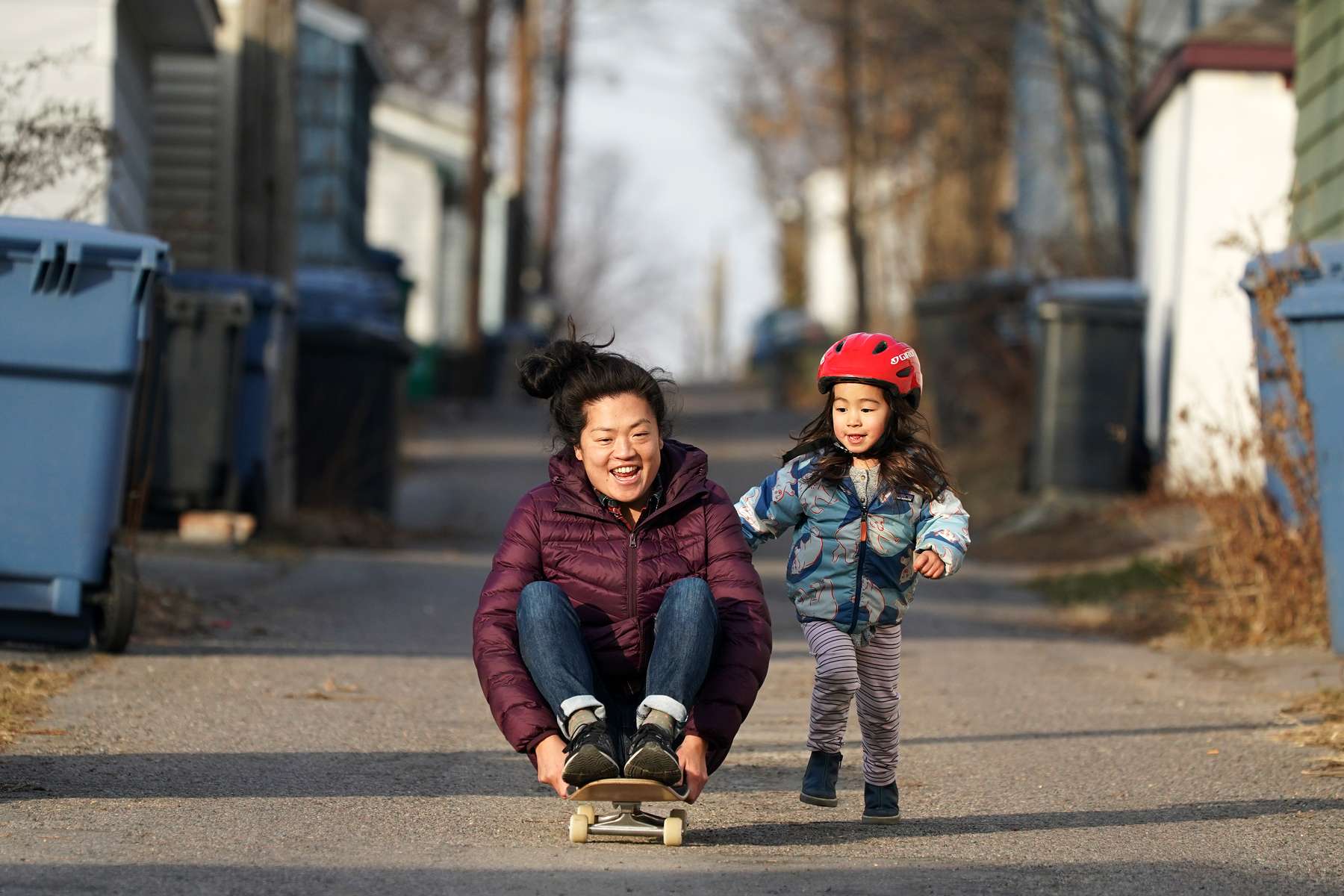 Leslie Kegan got a push from her daughter Lucille, 3, as she rode a skateboard down the alley behind their home on an unseasonably warm Decemeber day in northeast Minneapolis.