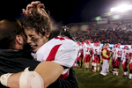 Naperville's Jack Wooldridge got a hug from his coach after winning an IHSA Class 8A football championship game against the Loyola Academy Ramblers at Huskie Stadium on the grounds of Northern Illinois University in DeKalb, Ill. 