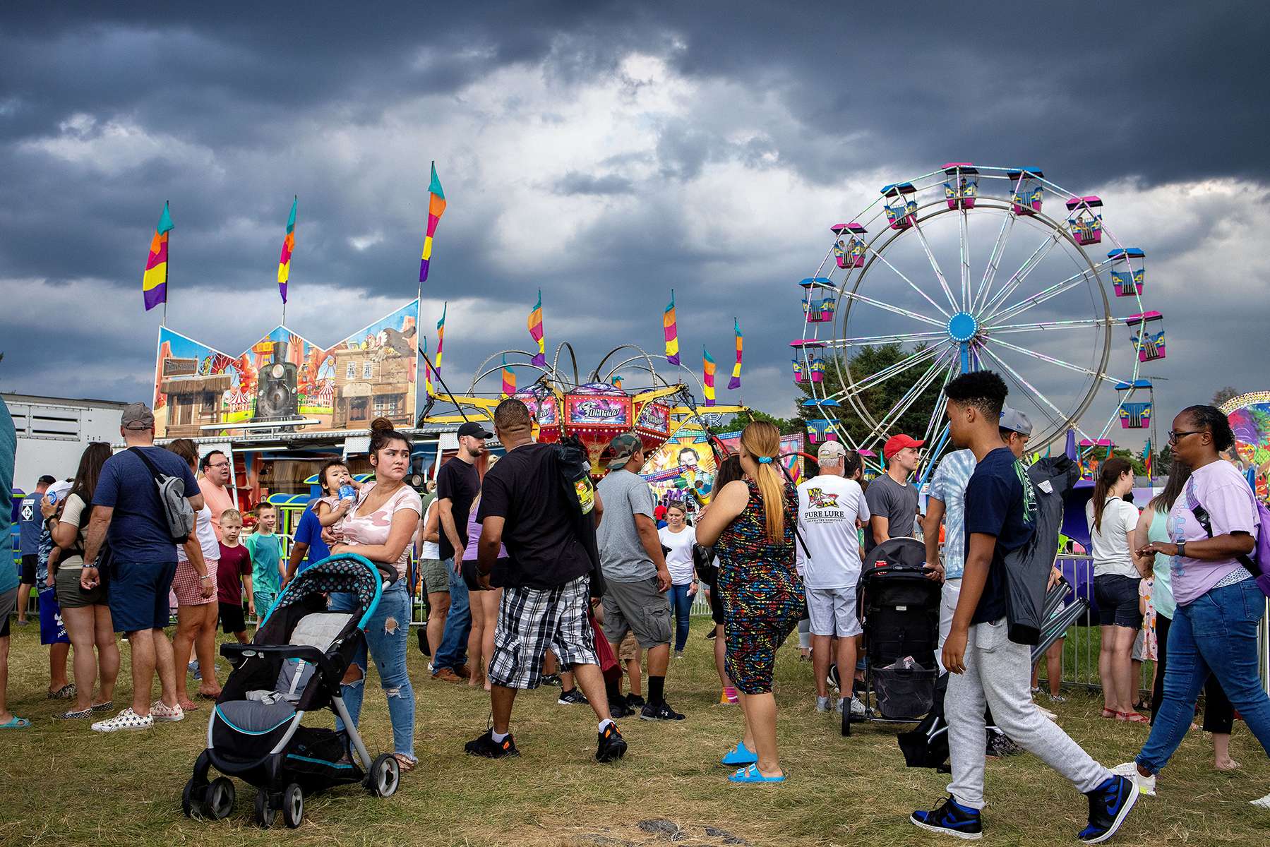 Visitors to the Walkersville Volunteer Fire Company Carnival walk through the carnival midway at the event in Walkersville, Maryland on July 9, 2021. Many volunteer fire departments, such as Walkersville, rely on summer carnivals and other community events throughout the year to fundraise for money to finance all their operating costs and equipment, such as the purchase of fire engines. According to the fire company, their first carnival was held in 1940. 