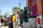 Chaundre Franklin (center), Miss Gettysburg Juneteenth 2022, and other participants in the Gettysburg Juneteenth Parade pause on the steps of the St Paul A.M.E. Zion Church in Gettysburg, Pennsylvania on June 19, 2022. Instead of a traditional parade, the organizers created an event where parade participants stopped at sites along the route that are historically important to Gettysburg’s African-American community. At each site, speakers would describe the historical significance of the place. A.M.E. Zion is the oldest congregation of African-American community members in Gettysburg and dates to 1838. The town of Gettysburg is itself significant for being the site of the deadliest battle of the American Civil War.