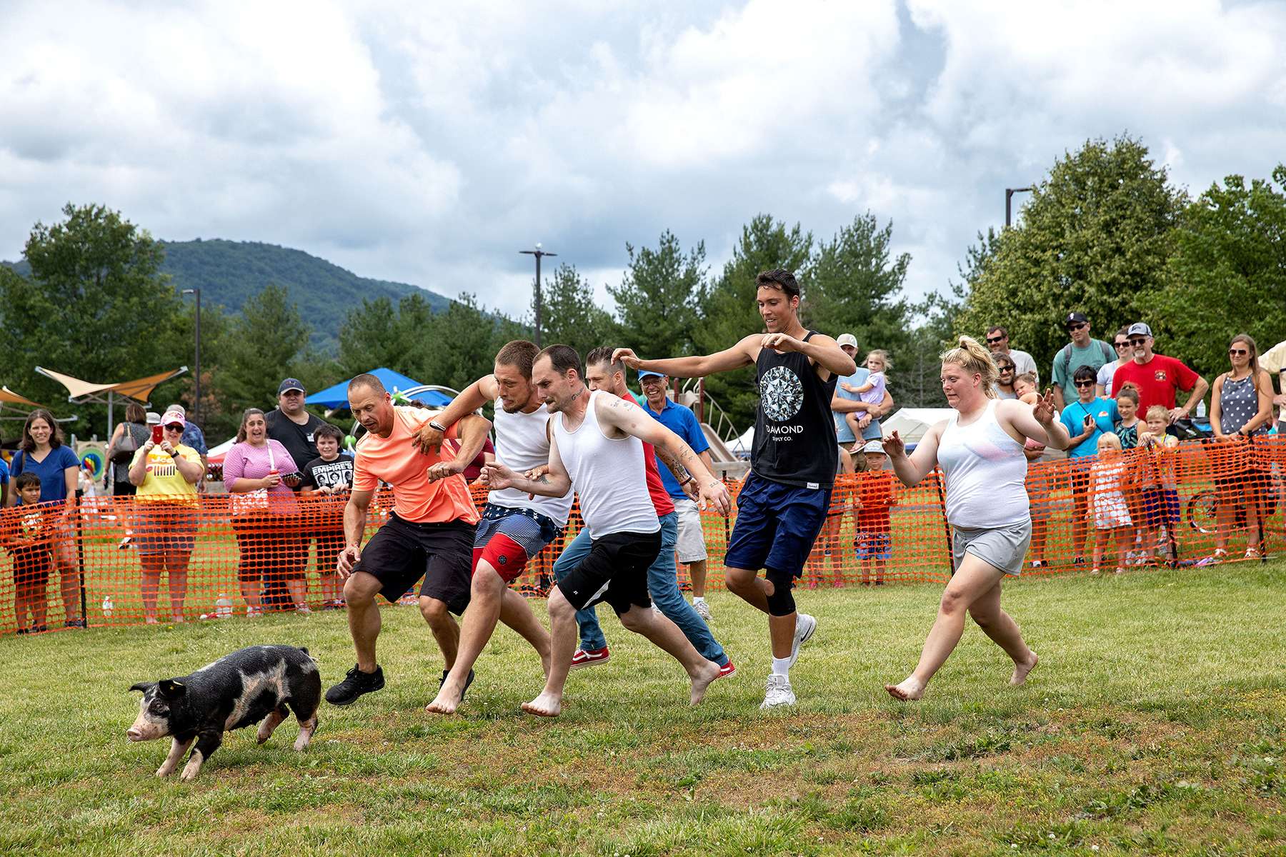 Competitors in the adult division of a “Grease The Pig” contest attempt to be the first to catch a pig while playing field games at the Emmitsburg Community Heritage Day in Emmitsburg, Maryland on June 26, 2021. The contest, often found at agricultural fairs and festivals, involves covering a pig with vegetable oil or shortening, making it slippery and difficult to catch. The heritage day was a full day of activities including the field games organized by the local Lions Club, a parade and fireworks. Organizers describe the theme of the day as a celebration of “Small Town America.”