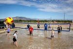 Competitors in a mud volleyball tournament play against each other during the competition at the Eureka County Fair in Eureka, Nevada on August 13, 2022. Organizers say they got the idea for volleyball in a mud pit from another county fair and it has since become an annual tradition of friendly competition against neighbors. Eureka, the county seat of Eureka County, bills itself as “The Friendliest Town on the Loneliest Highway.” At the time of the last census there were only 1,855 inhabitants in the entire county.