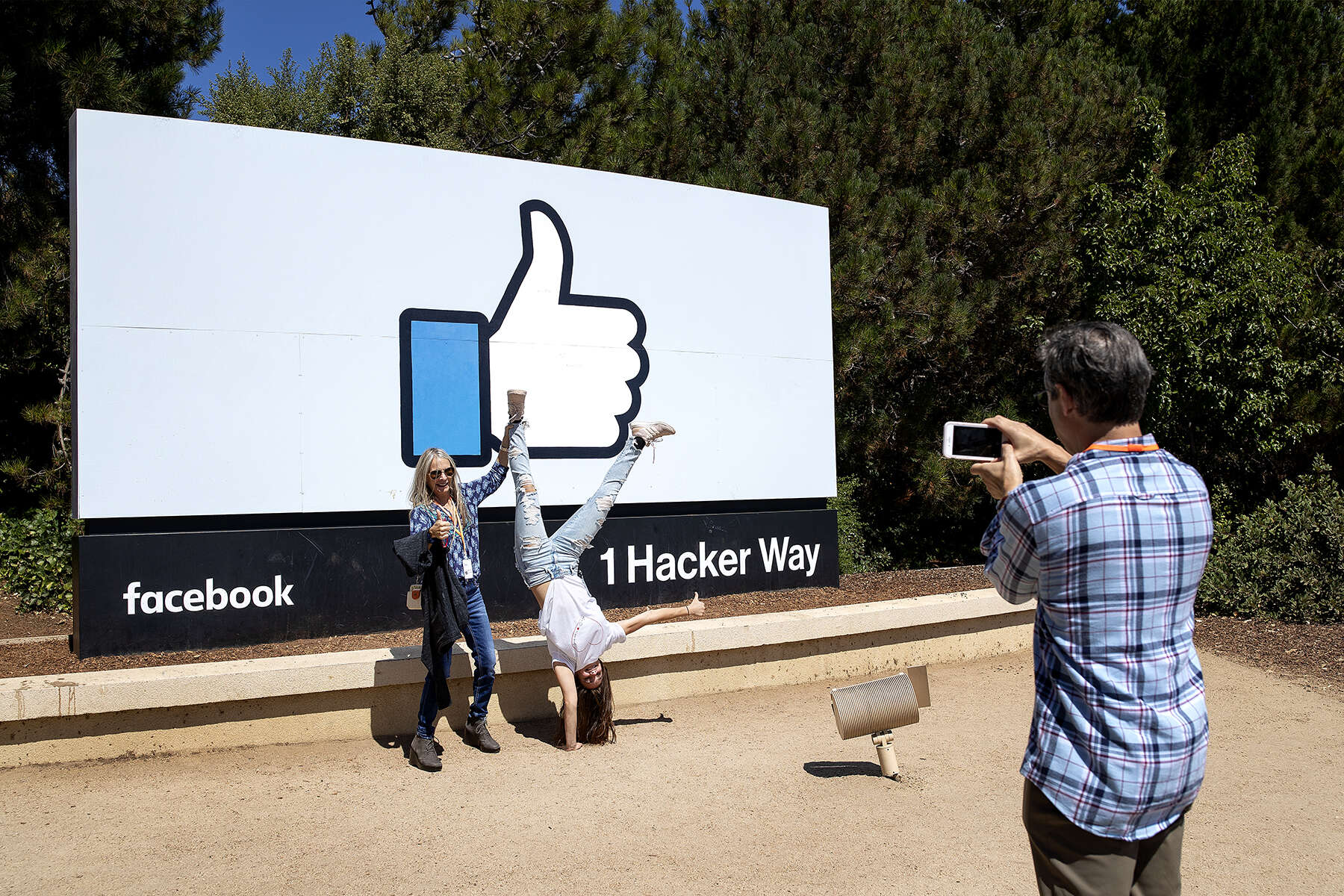 Nicole Voulgaropoulos and her mom, Sheryl Green-Voulgaropoulos, pose in front of Facebook’s thumbs-up sign as Mel Voulgaropoulos, her father, photographs them in Menlo Park, Calif., on August 31, 2018. Nicole was at the time a new Facebook employee and her parents had come for a visit. Access to the company’s campus is restricted and the sign, the area that welcomes visitors without an employee connection, has become a popular place to sightsee and take photos for people who visit Silicon Valley. 