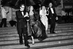 Alan Malouf (left) helps his friend Elisabeth Thieriot keep her gown dry while moving from dinner to the performance during a rainstorm at the San Francisco Ballet Opening Night Gala in San Francisco, Calif., on Thursday, January 19, 2012.This photograph is of a candid moment and was not directed in any way.