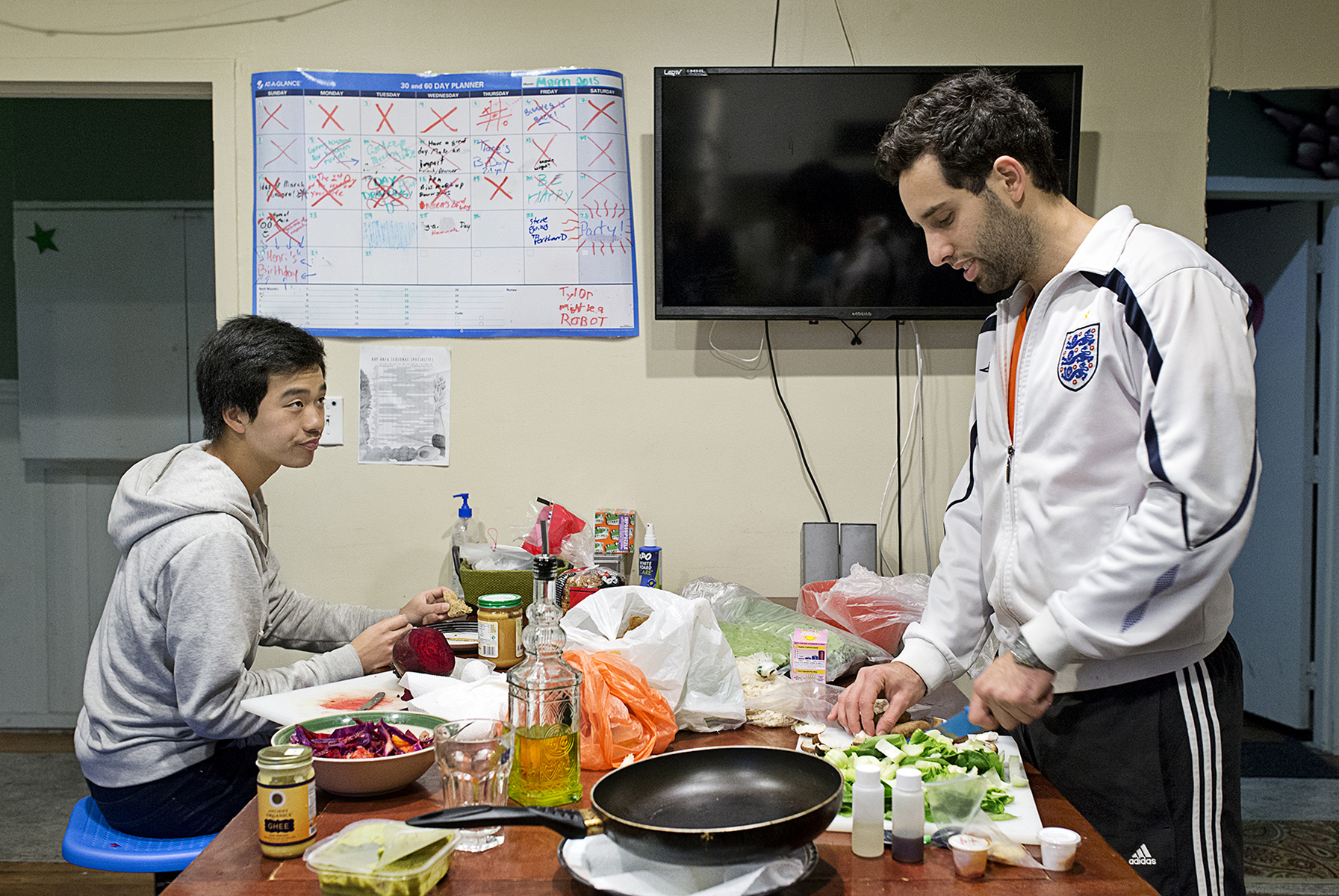 Lior Neu-ner (right) cooks while his housemate Darren Lee eats dinner in the communal kitchen at 20 Mission, a co-living house, in San Francisco, Calif., on Monday, March 23, 2015. Around 45 people live in the building, which is a former single room occupancy hotel that had been vacant for several years before being turned into the co-living space. Many of the residents are start-up entrepreneurs and the community is a mix of temporary occupants with people who have made the space their home on a more long-term basis. Neu-ner was living at 20 Mission for a few months while in San Francisco to participate in a start-up accelerator with his parking app Parko and Lee lived in the house temporarily while transitioning to the city.