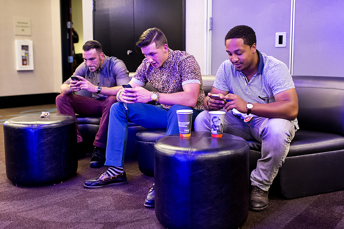 Danny Lizotte, Tim Lizotte and Colton Walker (left to right) check their phones while attending the Startup and Tech Mixer in support of a friend who was launching a job app at the event in San Francisco, Calif., on Friday, August 8, 2014.  The networking event is held once ever few months and draws hundreds of attendees.  
