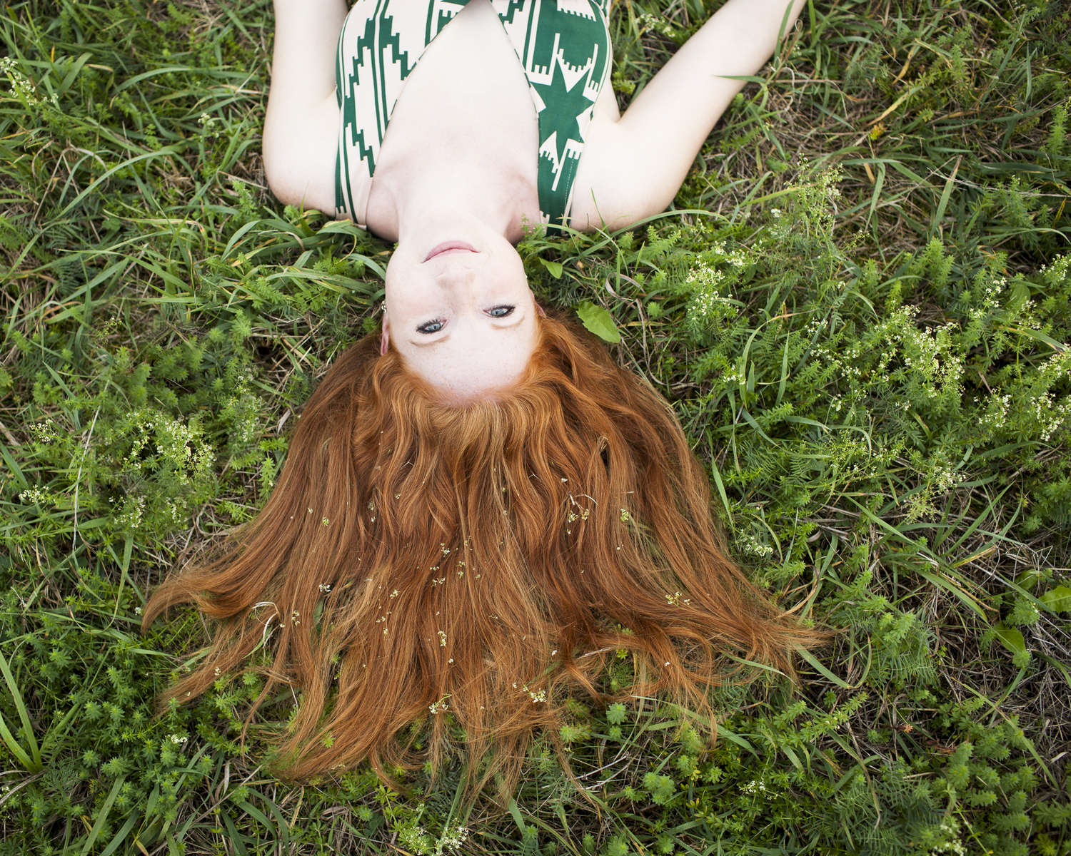 Redhead Shannon lying in the grass at All Souls in Shelburne, by Vermont photographer Judd Lamphere