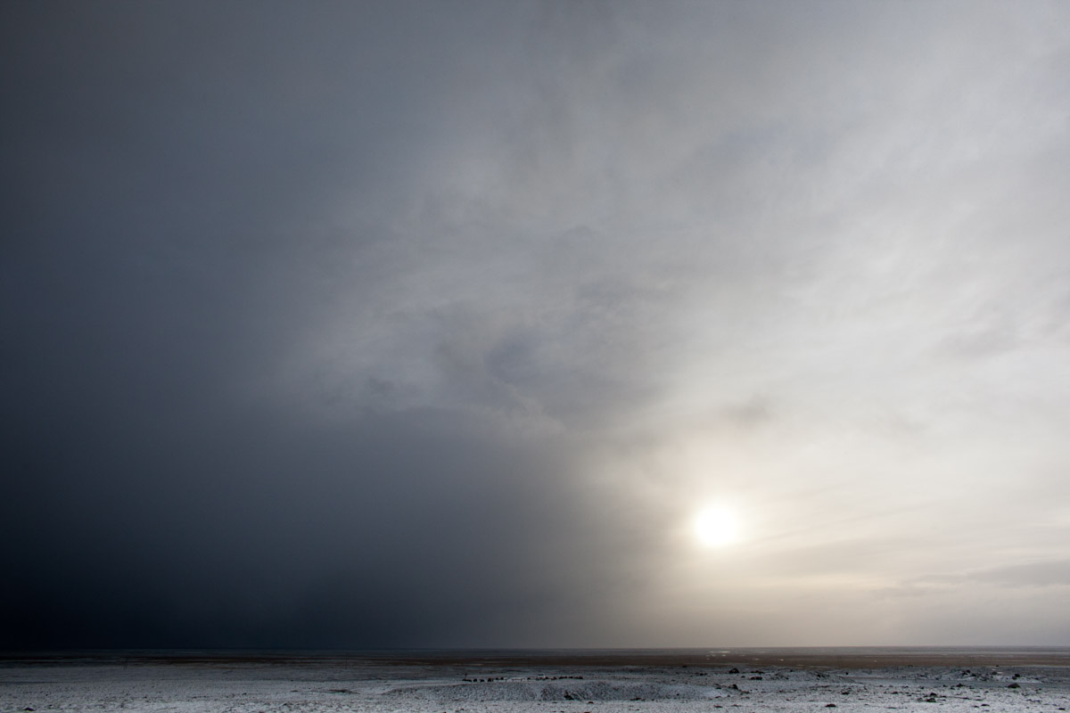Clouds cover the sun during a passing winter storm in Iceland. by Vermont photographer Monica Donovan