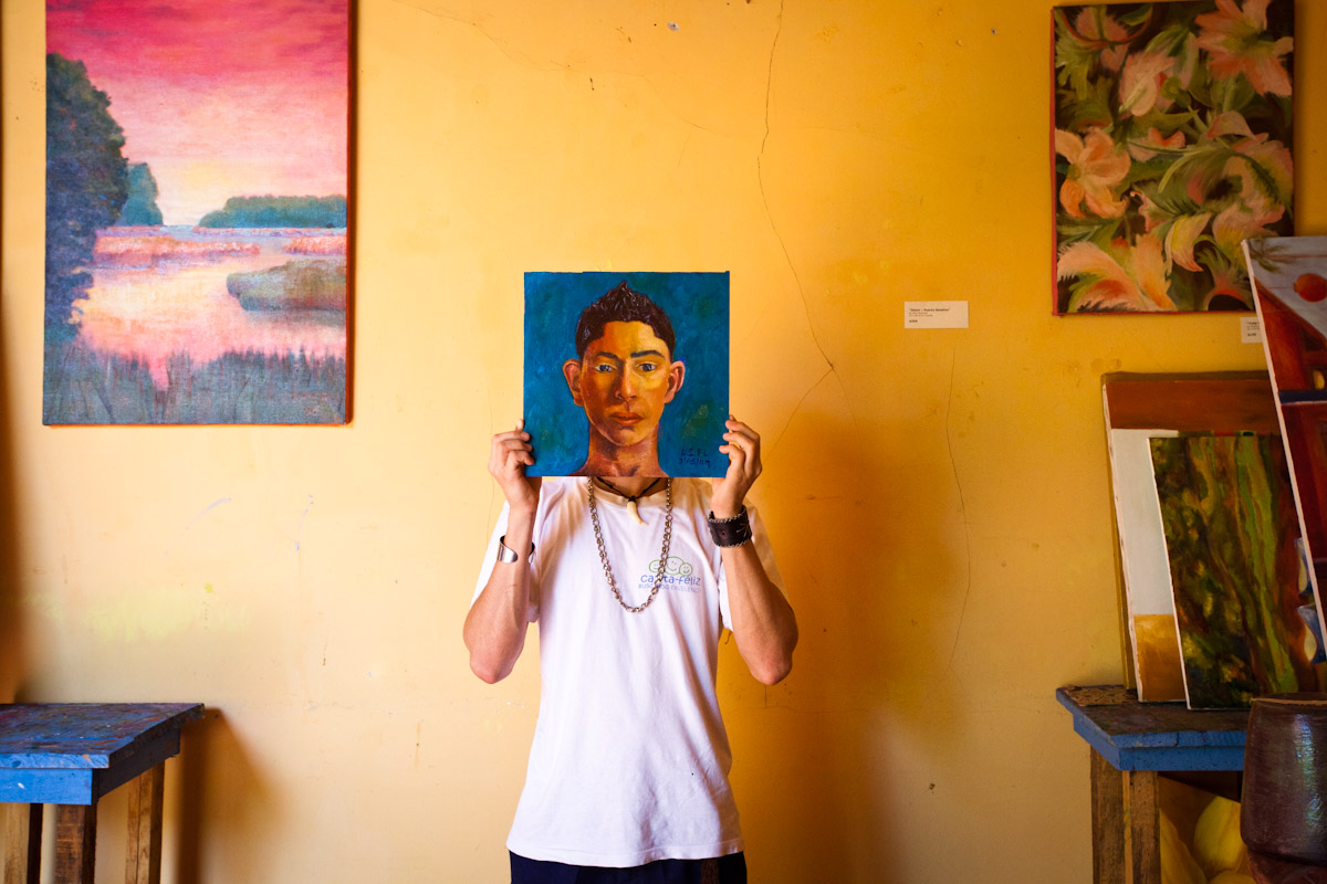 15 year-old Nicaraguan artist Luis Carlos holds up a self-portrait, Granada, Nicaragua.