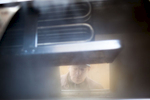 Man peers into an evaporator while sugaring during peak maple syrup season. By Vermont photographer Monica Donovan