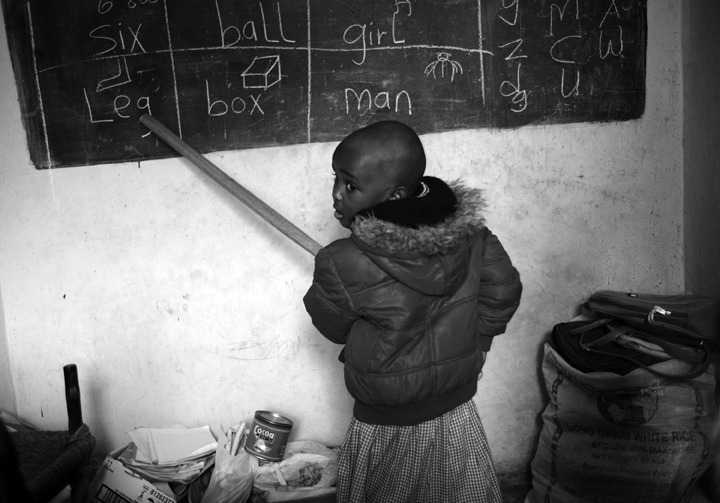 Linet Mueni, 4, reads from the blackboard in front of her classmates.