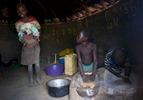 Agnes Alimo, 10, left, returns home from school with her one-year old brother (Regan Kidaga) because he would not stop crying.  Her sister Vicky Auma, 7, center, and a neighborhood boy, Ogen, 6 (who didn't know his last name) stayed home from school to crush groundnuts. Children constitute an invaluable source of stopgap labor for households re-establishing livelihood strategies in post-conflict northern Uganda.  