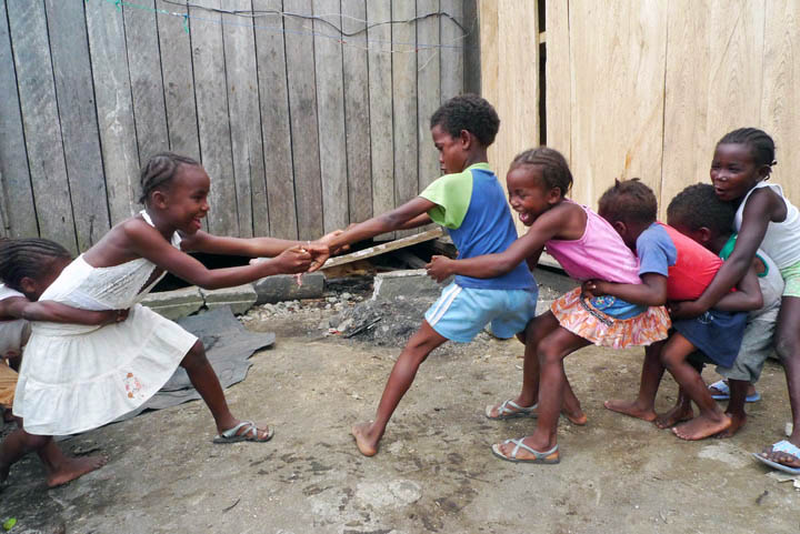 Afro-Ecuadorian children play tug-of-war.