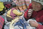 Nancy Avila, 29, right, chews coca leaves while Hilda Cahuana, 40, grinds ore in search of gold. 