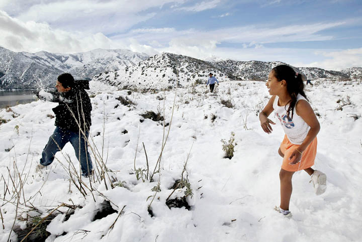 Katie Sanchez, 11, right, has a snowball fight with her brother Rudy, 13, after their family stopped along the highway to view the snow about fifteen miles north of Los Angeles.