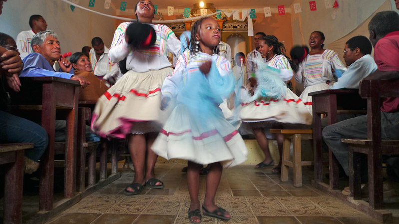 An Afro-Bolivian dance troupe performs for churchgoers during a celebration marking a religious festival ({quote}Fiesta de San Benito{quote}).