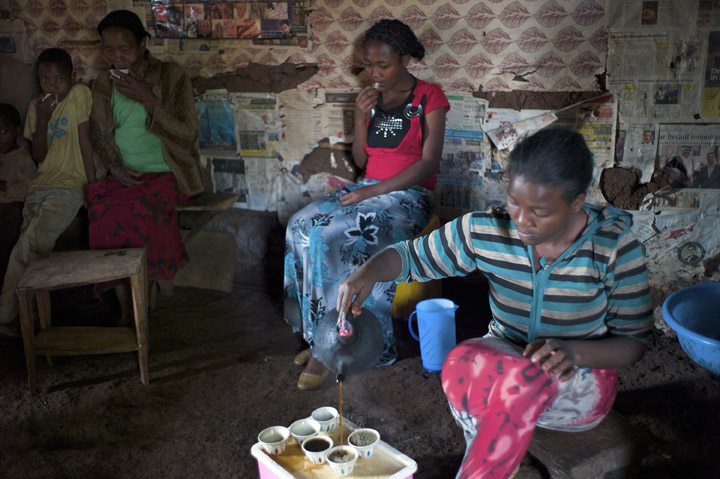 January 22, 2014 - Magala Lemefa Village, Ethiopia - Beneficiary Hirbaye Shorre's, 46,  second from left, daughter, Bekelech Shorre, 15, right, serves coffee to the family and neighbors such as Martha Kute, 18, second from right. Hirbaye Shorre grew the coffee being consumed. She's a member of the Homa Multipurpose Cooperative  and as such received a loan to rear sheep.  (Photo by Ric Francis)