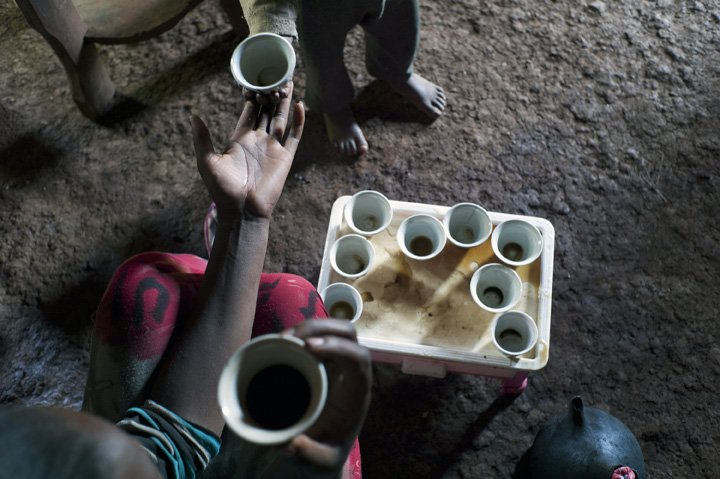 January 22, 2014 - Magala Lemefa Village, Ethiopia - Bekelech Shorre, 15, the daughter of beneficiary Hirbaye Shorre, 46, collects an empty coffee cup from her 4-year old cousin (Jaleta Tariku). Her mother grew the coffee being consumed.  (Photo by Ric Francis)
