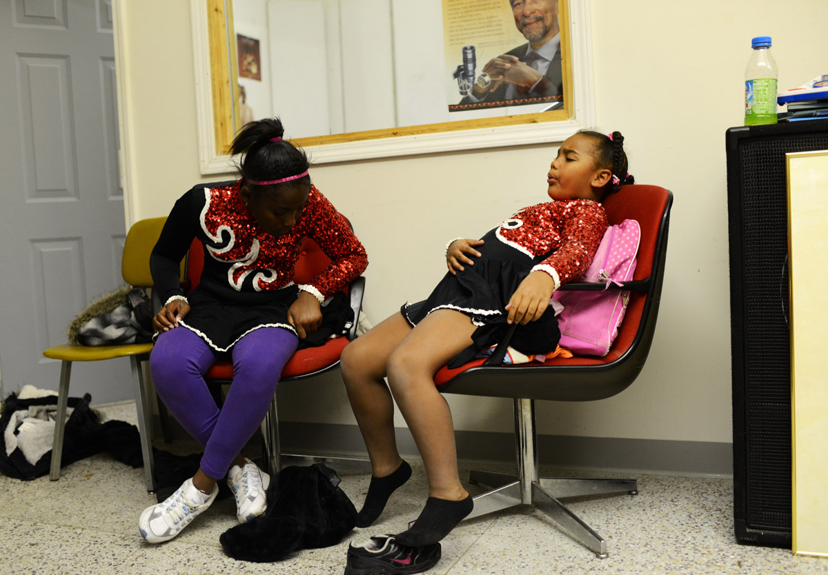One of the youngest members of the Hillcrest High Steppin' Majorettes, Lonna Hayes, 6, takes a load off while others are fitted for their parade uniforms at the WRES radio station offices Wednesday evening.11-7-12 - Erin Brethauer (ebrethau@citizen-times.com)