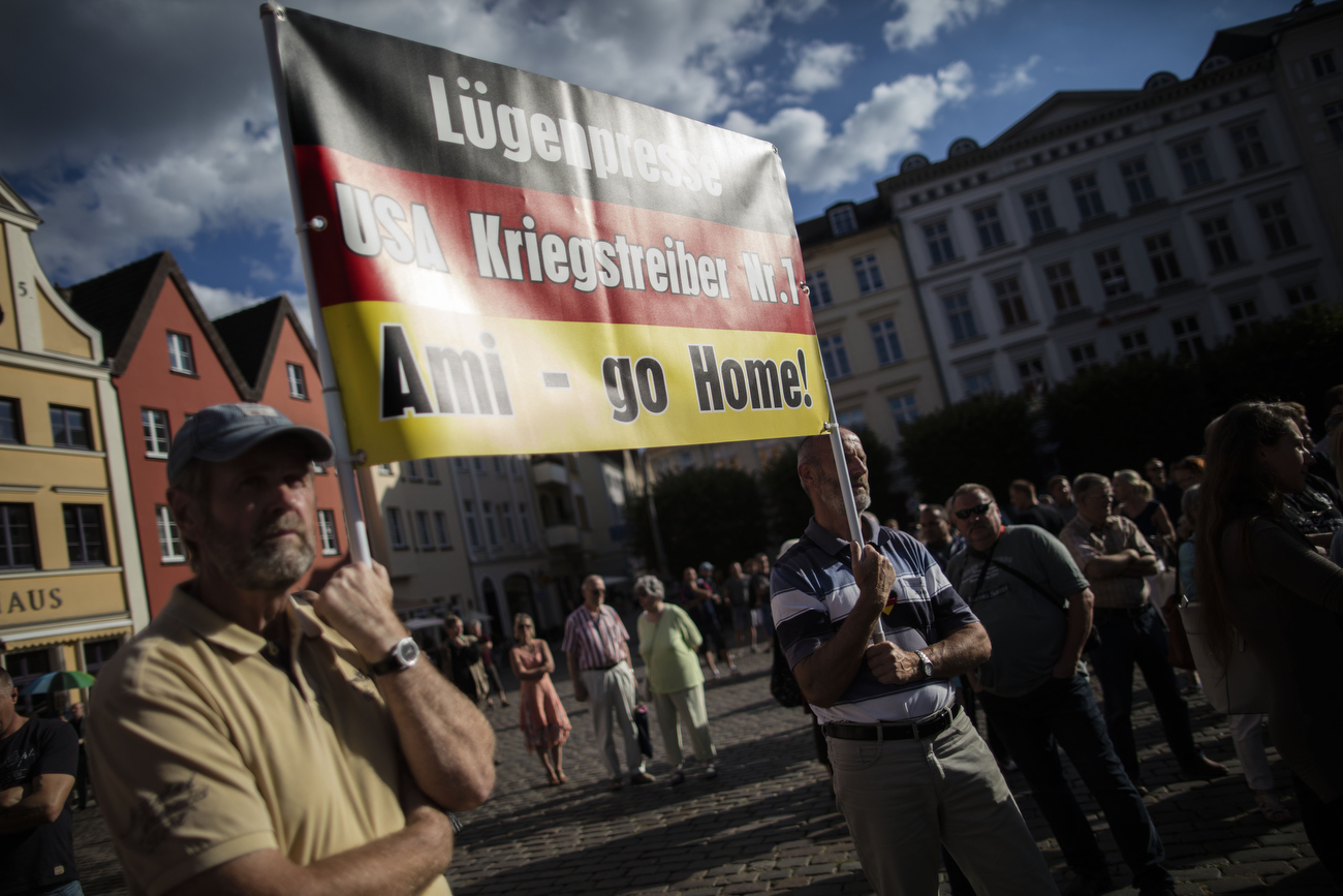 August 19, 2016 -Schwerin, Germany: AfD supporters hold a placard that reads: Luegenpresse (press liars) and 'Ami go home' as Bjoern Hoecke, head of the Alternative fuer Deutschland political party (Alternative for Germany, AfD) in Thuringia and Leif-Erik  Holm, lead candidate for the AfD in Mecklenburg Western Pomerania agitate a small crowd at an AfD party rally. The anti-immigration party is surging after Germany took in most of the more than 1 million refugees who arrived in the European Union last year. The party’s rise is narrowing coalition-building options for Germany’s established parties and threatens the status quo nationwide. Polls suggest the AfD will win up to 19% of the votes in this east German state of Mecklenburg-Western Pomerania, where Germanys Chancellor Merkel has her electoral district. 