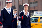 Three men dressed up as sailors wearing hats saying {quote}Jeanne' D'Arc{quote} talk up West Broadway and Worth Street in Soho 