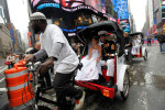 Newlyweds ride out of Times Square after their wedding ceremony on a rickshaw