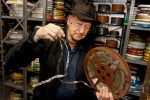Artist Jonas Mekas holding the orginal reel of Kenneth Anger's {quote}Fireworks{quote} at Anthology Film Archives