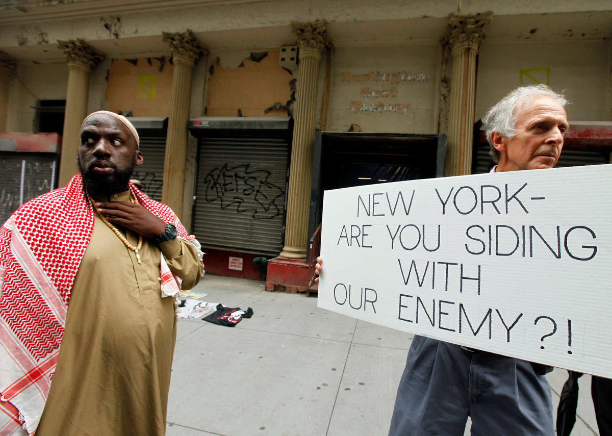 Imam Hassan, from Newark, New Jersey, right, om his way to prayers is greeted with protest outside of the Park51 Islamic center, the so called {quote}Ground Zero Mosque{quote} 