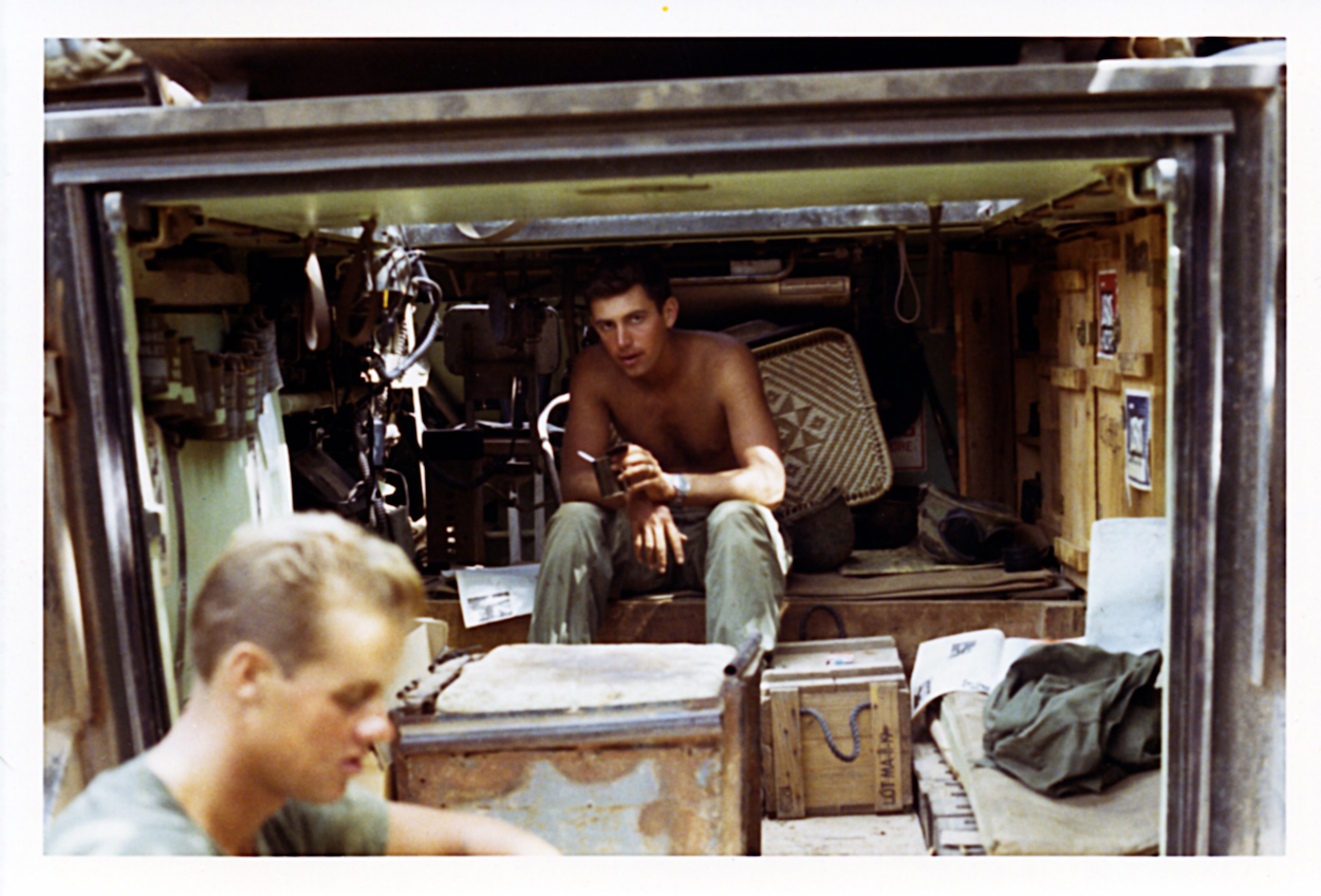Captain Kirkland L. Alford, A Troop, 3/4 Cav, commander, sits inside the A-6 track while he has a lunch of C-rations. I think that is the A-6 driver in the foreground.