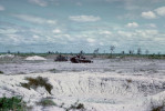An M48 tank waits for an M88 VTR to arrive to tow it out for repair.