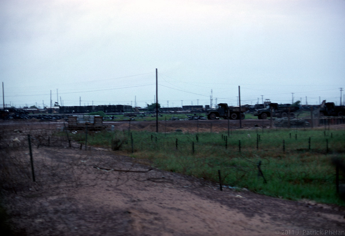 The perimeter near the main gate of our base camp, Cu Chi.  Several rows of barbed wire, or concertina wire, can be seen in the foreground.